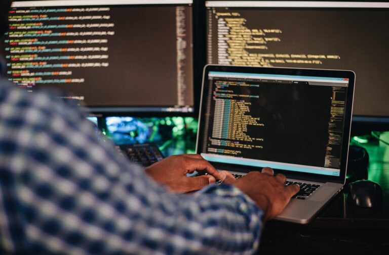 Homme assis à un ordinateur, travaillant sur des solutions informatiques de dépannage et d'optimisation chez Teclab.