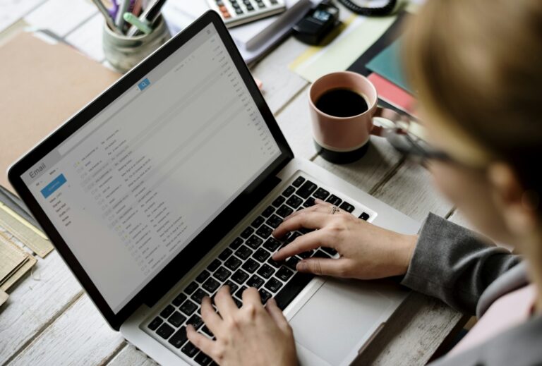 Femme d'affaires vérifiant ses e-mails en ligne sur un ordinateur portable, illustrant l'optimisation et l'assistance de Teclab pour un usage professionnel